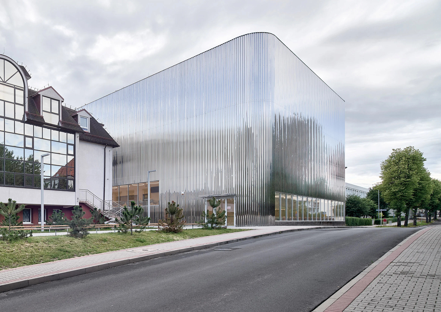 SLAS Architekci окутывает польский концертный зал зеркальным стальным фасадом