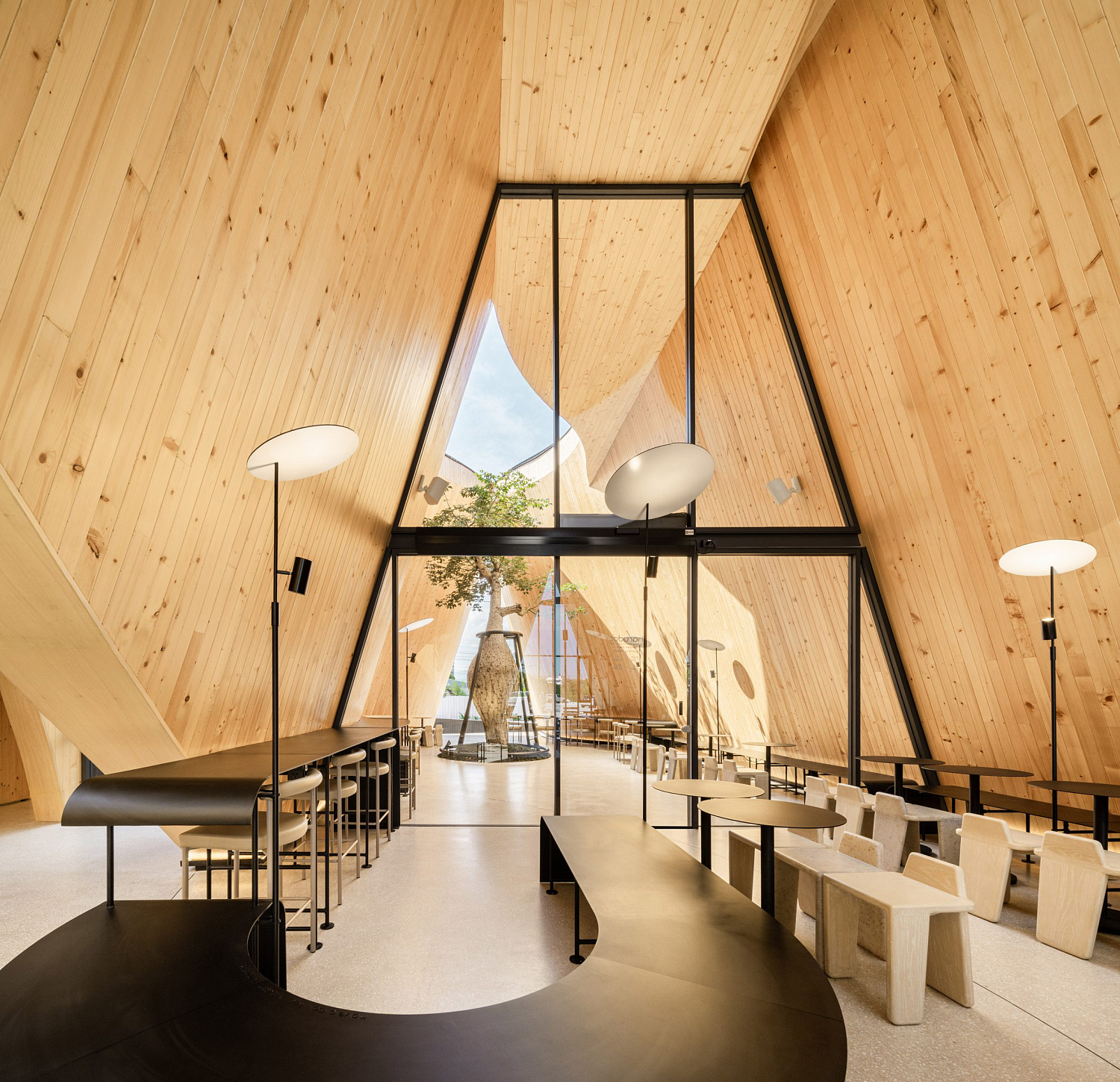 Дерево баобаб растёт в изогнутом кафе в Таиланде от IDIN Architects