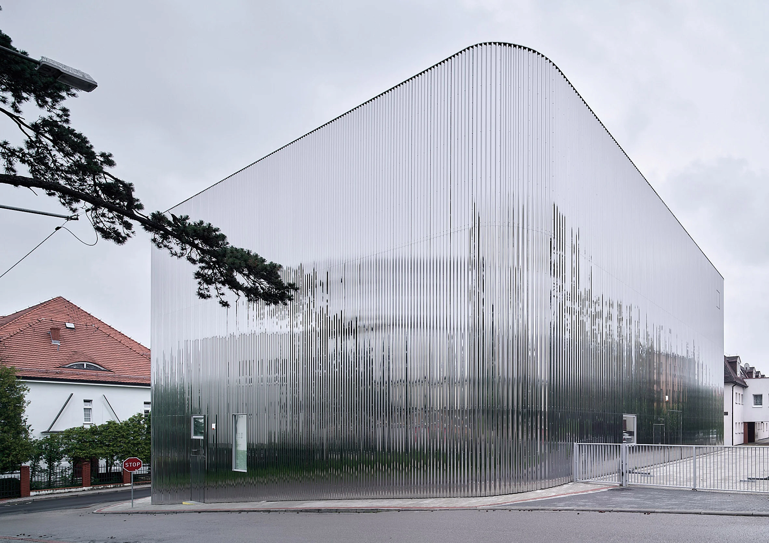 SLAS Architekci окутывает польский концертный зал зеркальным стальным фасадом